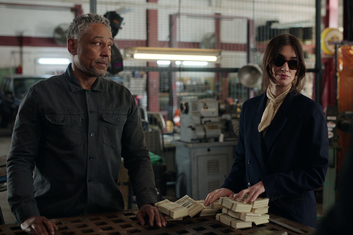 Giancarlo Esposito and Paz Vega stand at a table in Netflix’s Kaleidoscope