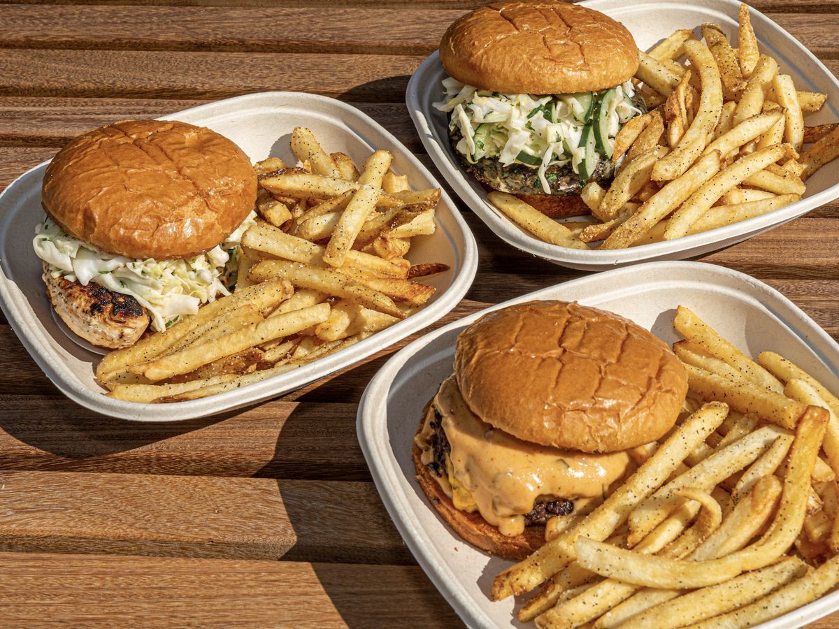 Three cardboard trays of burgers and fries.
