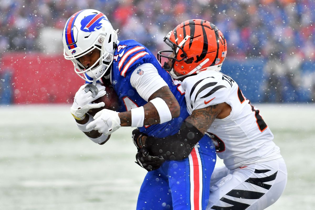 Jan 22, 2023; Orchard Park, New York, USA; Buffalo Bills wide receiver Stefon Diggs (14) makes a catch while defended by Cincinnati Bengals cornerback Cam Taylor-Britt (29) during the first quarter of an AFC divisional round game at Highmark Stadium. Mandatory Credit: Mark Konezny-USA TODAY Sports