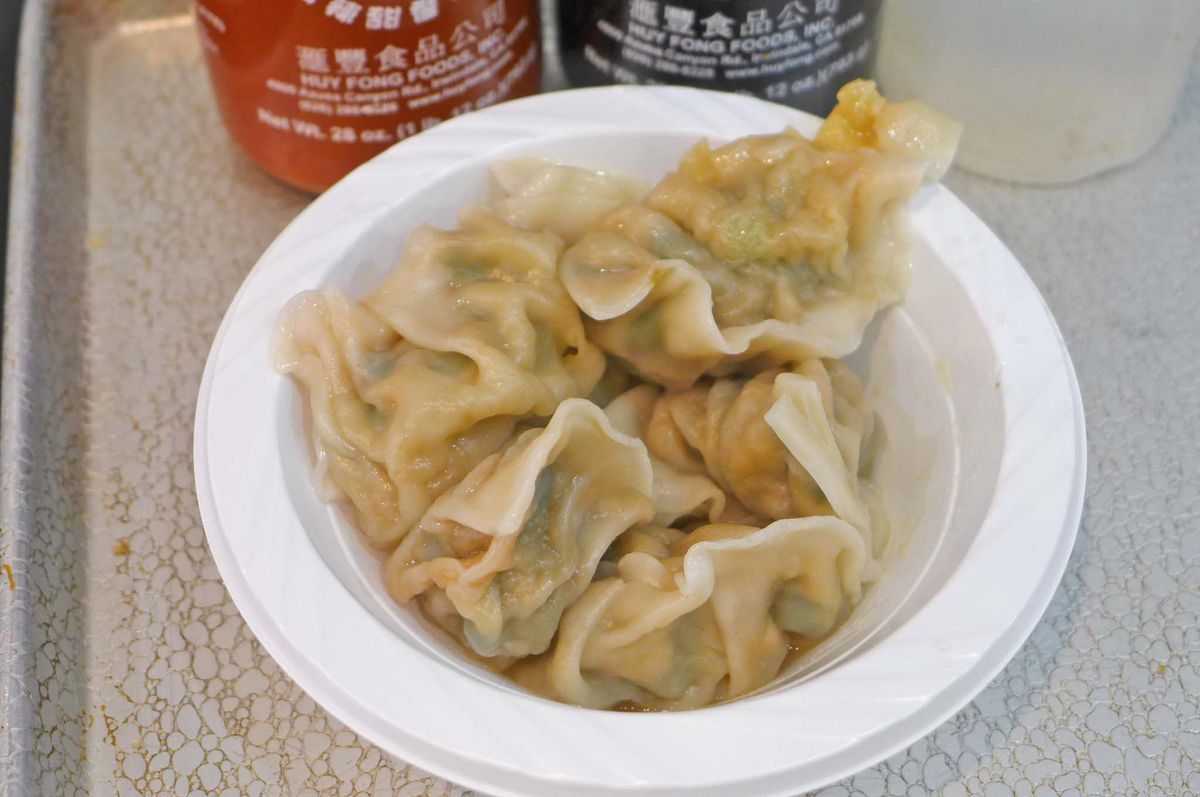 A white plastic bowl with six wobbly steamed dumplings.