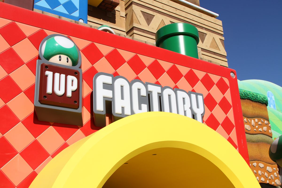 Signage and Warp Pipe-inspired entrance to Super Nintendo World's gift shop, called 1-Up Factory.