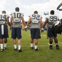 Players hold hands before running onto the field for a scrimmage during a BYU football practice at BYU's practice fields Thursday, Aug. 14, 2014.