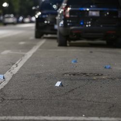 Bullet casings are marked with blue cards as police investigate the scene at the corner of W Douglas Blvd and S Ridgeway Ave in Lawndale, Wednesday, July 21, 2021.