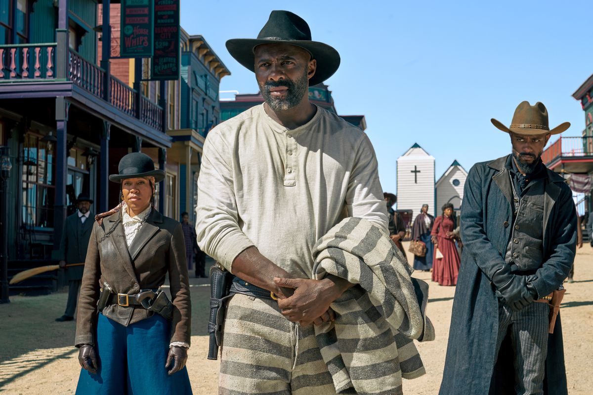 Regina King, Idris Elba, and LaKeith Stanfield in Western duds, arrayed across the street of an Old West town in The Harder They Fall.