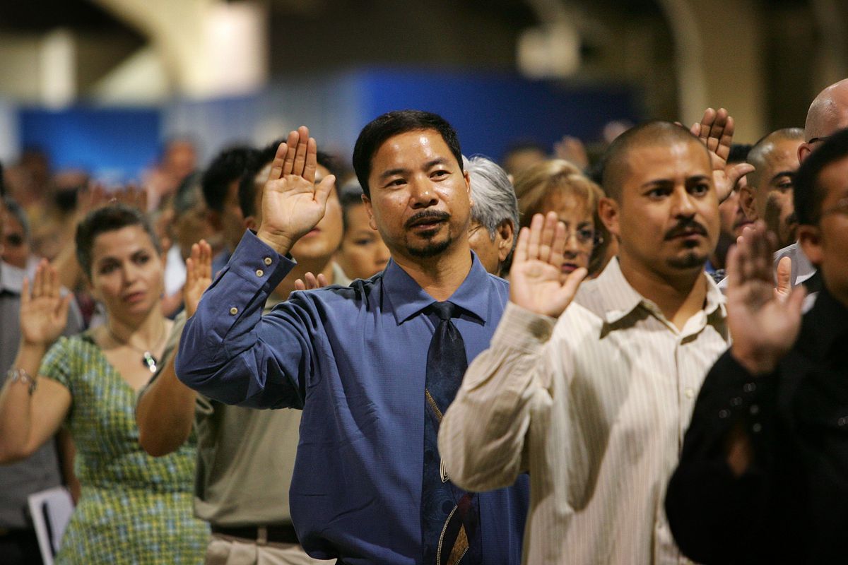 Participants raise their right hands during a naturalization ceremony in Pomona, California