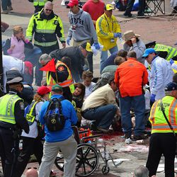 Medical workers aid injured people at the 2013 Boston Marathon following an explosion in Boston, Monday, April 15, 2013. Two explosions shattered the euphoria of the Boston Marathon finish line on Monday, sending authorities out on the course to carry off the injured while the stragglers were rerouted away from the smoking site of the blasts. 