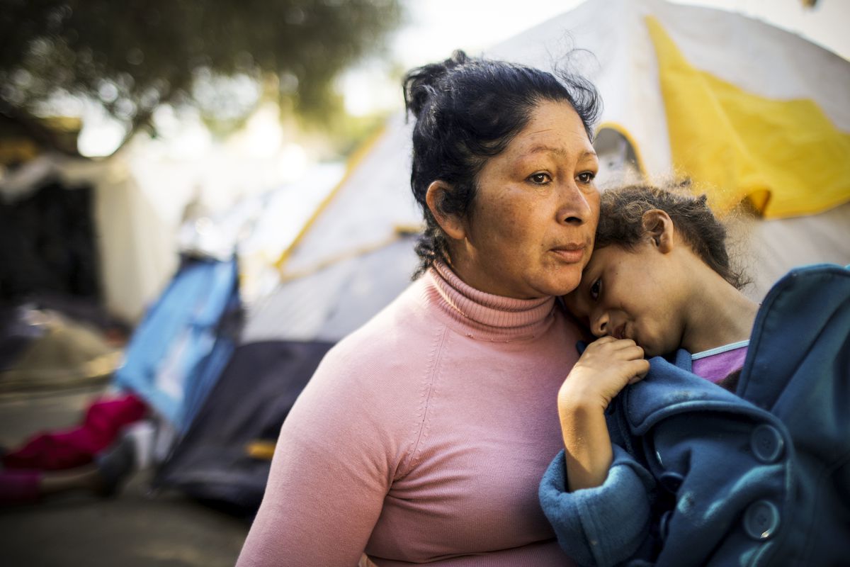 Honduran members of the 'migrant caravan' sit in a temporary shelter set up for members of the caravan on November 26, 2018 in Tijuana, Mexico.