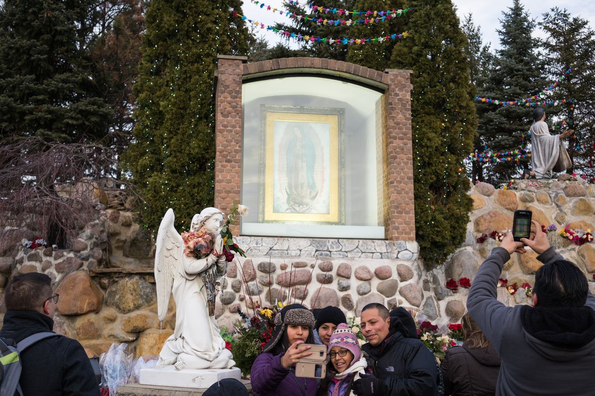 People take photos following a procession at the Shrine of Our Lady of Guadalupe in Des Plaines in December 2017.