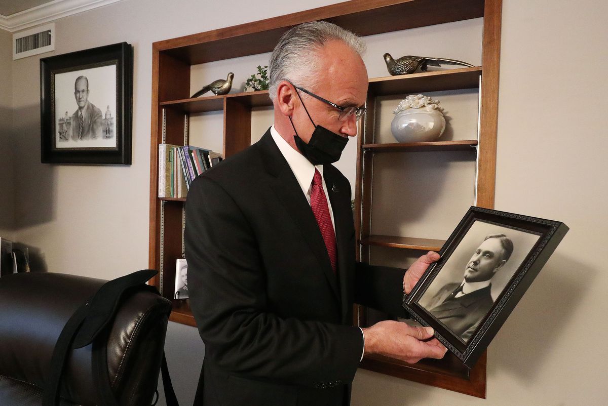 Kurt Soffe looks at a photo of his grandfather George A. Jenkins in his office at Jenkins-Soffe Funeral Homes and Cremation Center in Murray on Friday, Feb. 12, 2021. On the wall behind him is a photo of this other grandfather, Vaughn Soffe.