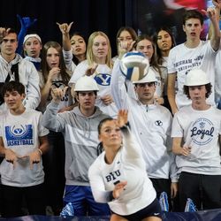 BYU student fans watch as Whitney	Bower serves the ball against Utah in an NCAA volleyball game at Smith Fieldhouse in Provo on Saturday, Dec. 4, 2021.