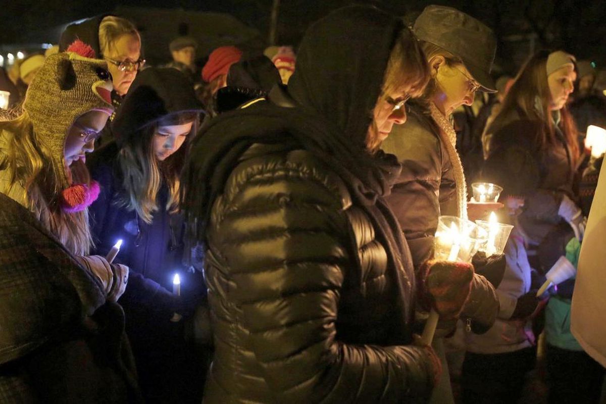 FILE - In this Jan. 29, 2016 file photo, people hold candles in memory of the three deceased Sheboygan Falls children at River Park in Sheboygan Falls, Wis. Natalie Renee Martin, 11, Carter Maki, 7, and Benjamin Martin, 10, died in a house fire Jan. 26. N