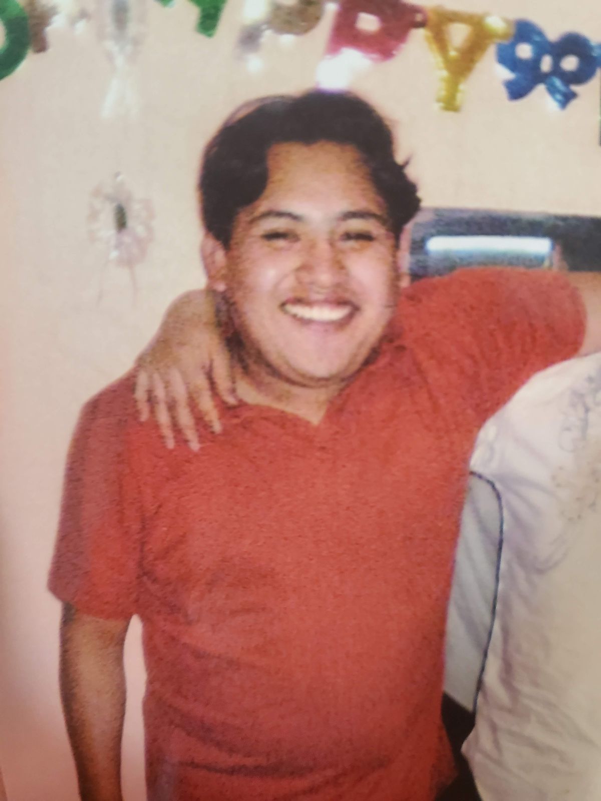 Victor Morales smiling and wearing a red shirt