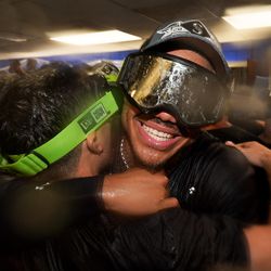 Julio Rodriguez #44 of the Seattle Mariners hugs a teammate in the locker room after the teams Wild Card game two win over the Toronto Blue Jays at Rogers Centre on Saturday, October 8, 2022