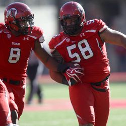 Utah's LT Tuipulotu (58) recovers a fumble and runs with the ball next to Utah defensive end Nate Orchard (8) during the first half of a football game at the Rice-Eccles Stadium in Salt Lake City on Saturday, Nov. 30, 2013.