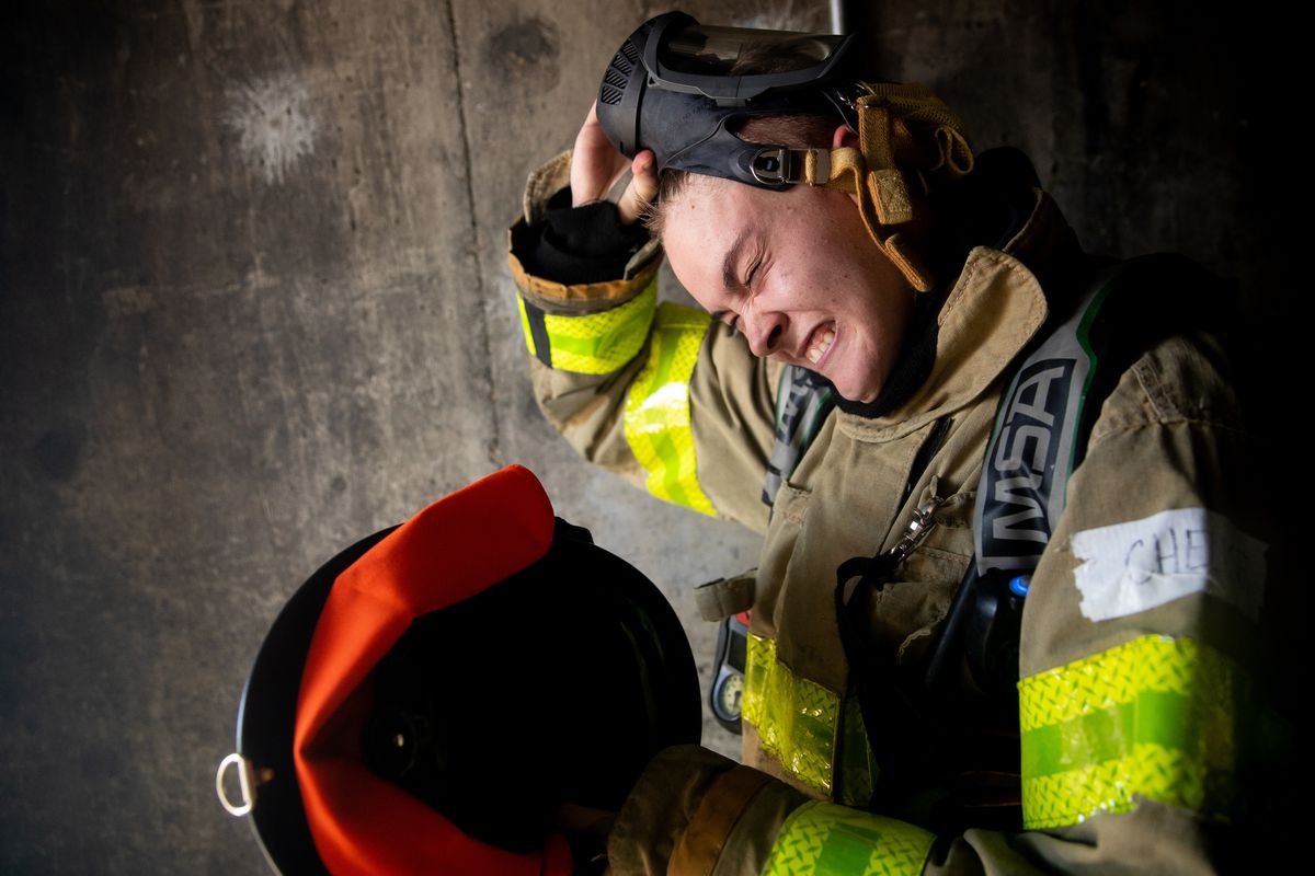 Chelise Schaefer, 19, removes her breathing apparatus after attacking a simulated apartment fire during Camp Athena, an opportunity for young women to learn what it takes to become a firefighter, at the Salt Lake City Fire Department’s training center on Saturday, Sept. 14, 2019.