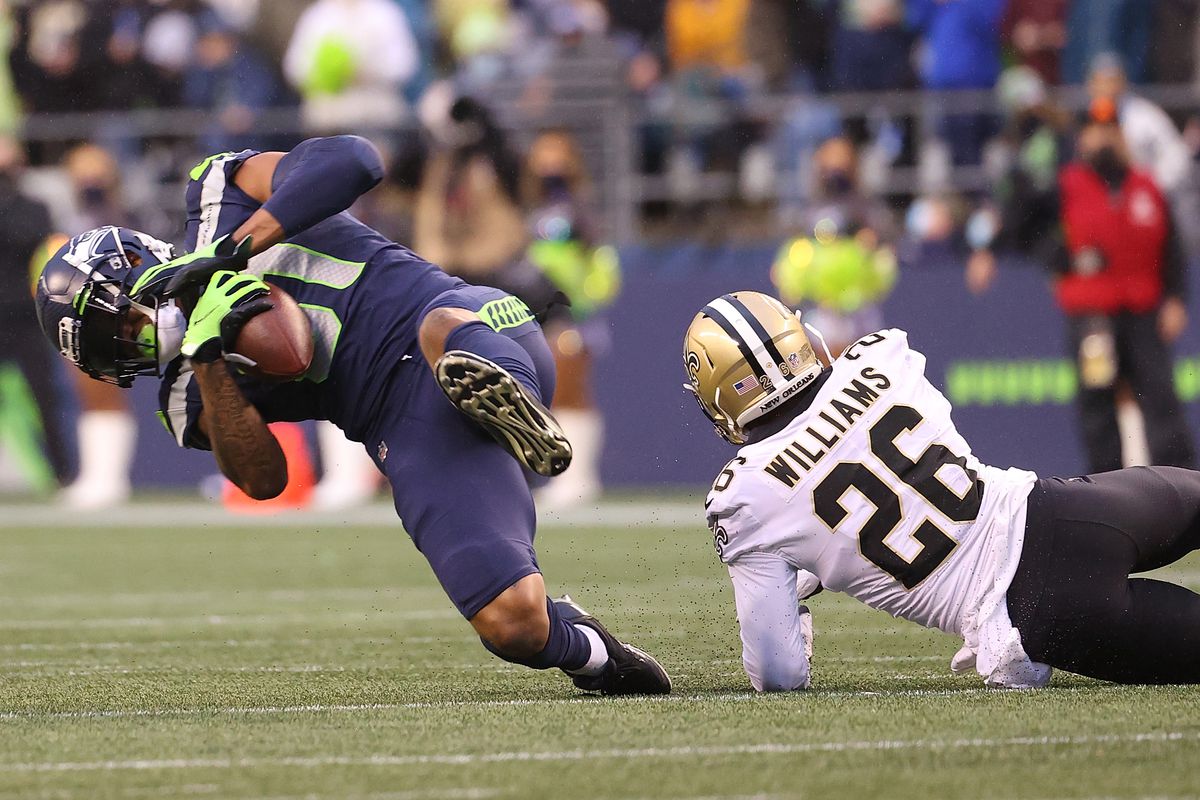 Gerald Everett #81 of the Seattle Seahawks is brought down by P.J. Williams #26 of the New Orleans Saints during the first half at Lumen Field on October 25, 2021 in Seattle, Washington.