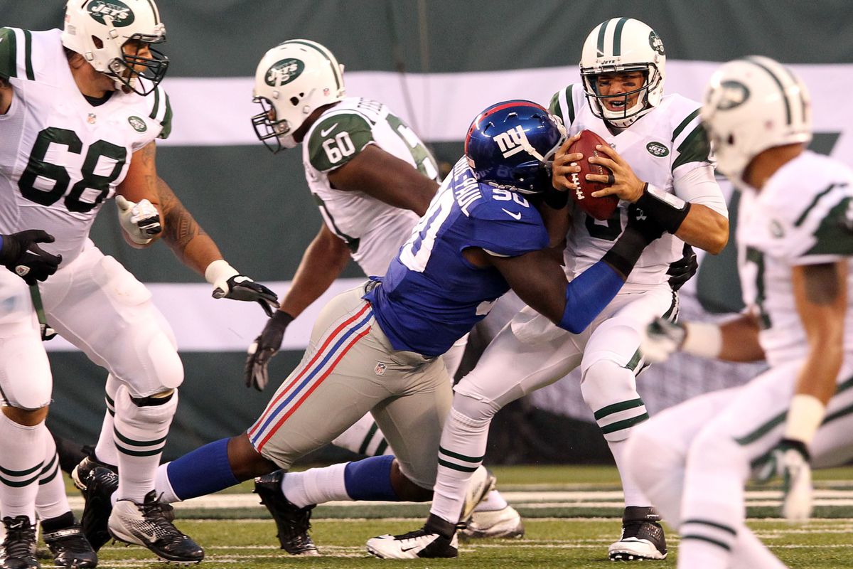 August 18, 2012; East Rutherford, NJ, USA; New York Jets quarterback Mark Sanchez (6) is sacked by New York Giants defensive end Jason Pierre-Paul (90) during the first quarter of a preseason game at MetLife Stadium. Brad Penner-US PRESSWIRE