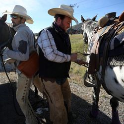 Josh White, left, leads Soda into a trailer as Jess Jones gets ready to ride Chief at the the Jeremy Ranch exit of I-80 in Park City on Thursday, Oct. 2, 2014. The riders take turns driving or riding in the Grass March Cowboy Express.