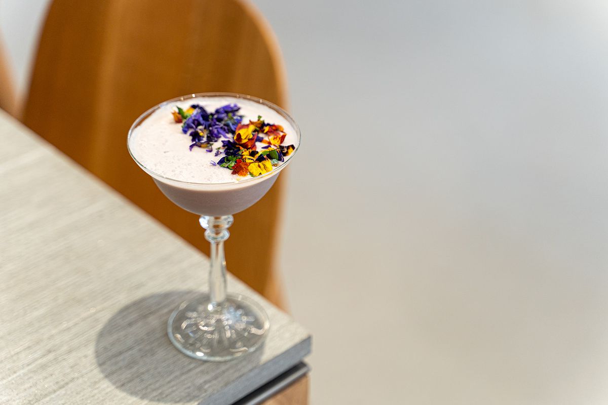 A creamy cocktail garnished with flowers.