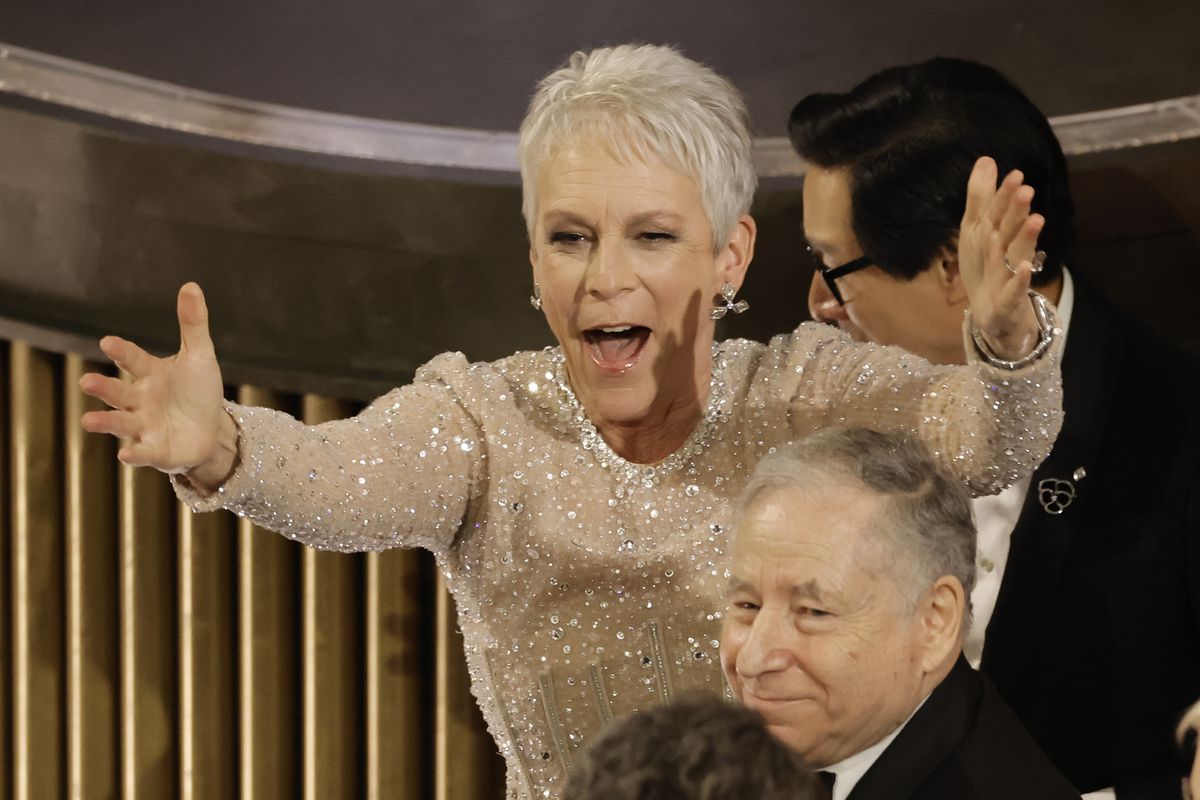 Jamie Lee Curtis holds up her arms in triumph during the presentation for the Best Picture award for Everything Everywhere All at Once during the 95th Annual Academy Awards