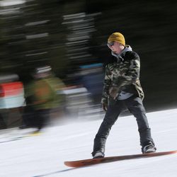 A snowboarder enjoys the warm temperatures Sunday, Feb. 8, 2015, at Brighton Ski Resort.