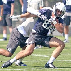 USU linebacker Suli Tamaivena brings down Aggie tight end Dax Raymond (87) following a reception during Friday afternoon's practice in Logan.