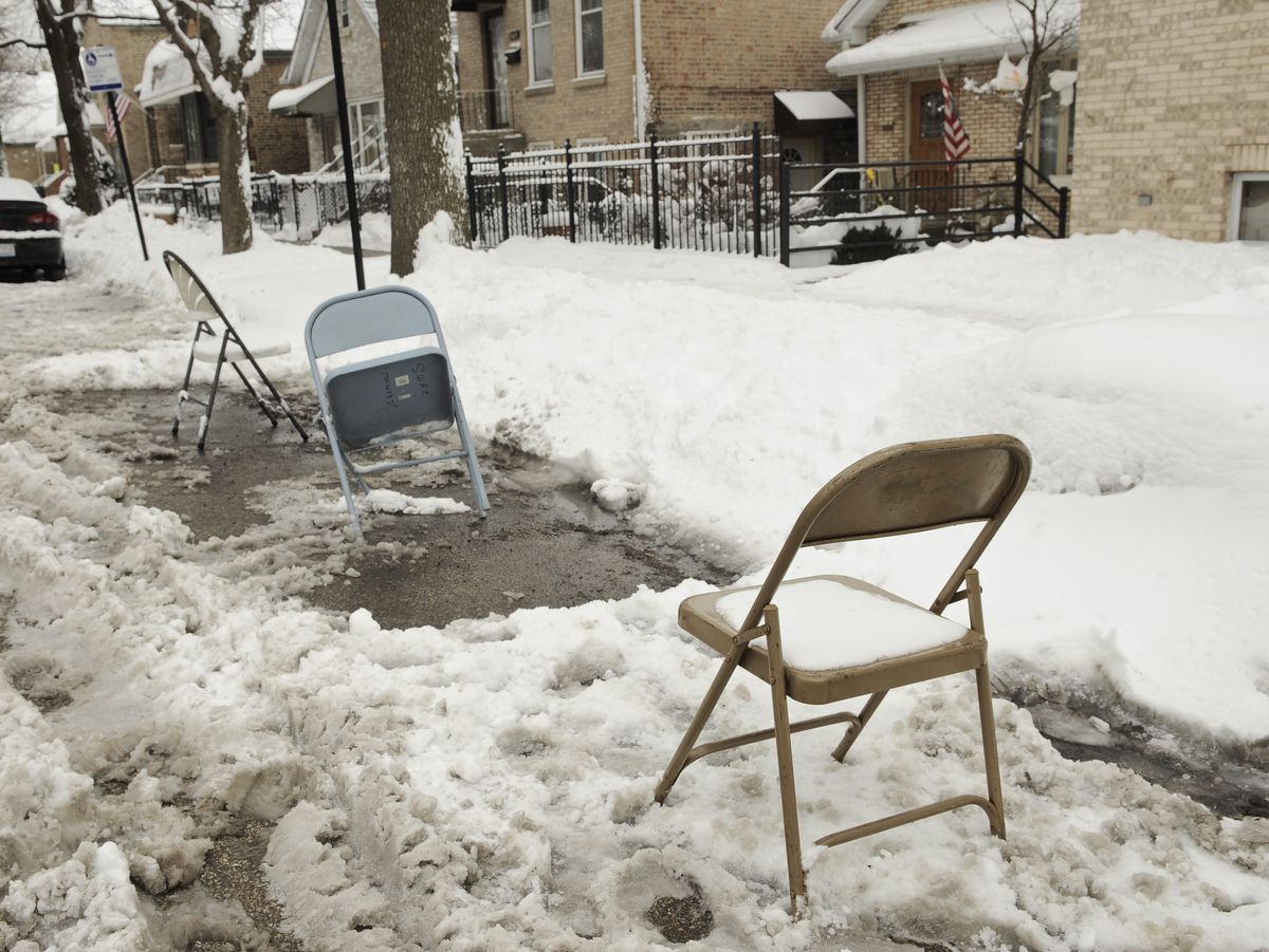 Folding chairs were put in parking spots cleared along a street in the Bridgeport neighborhood after a snowstorm to reserve it.