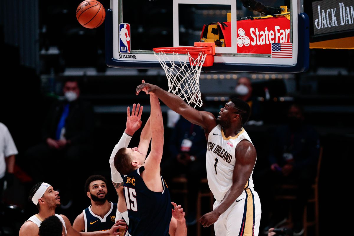 New Orleans Pelicans forward Zion Williamson (1) knocks away the shot of Denver Nuggets center Nikola Jokic (15) during the fourth quarter at Ball Arena.