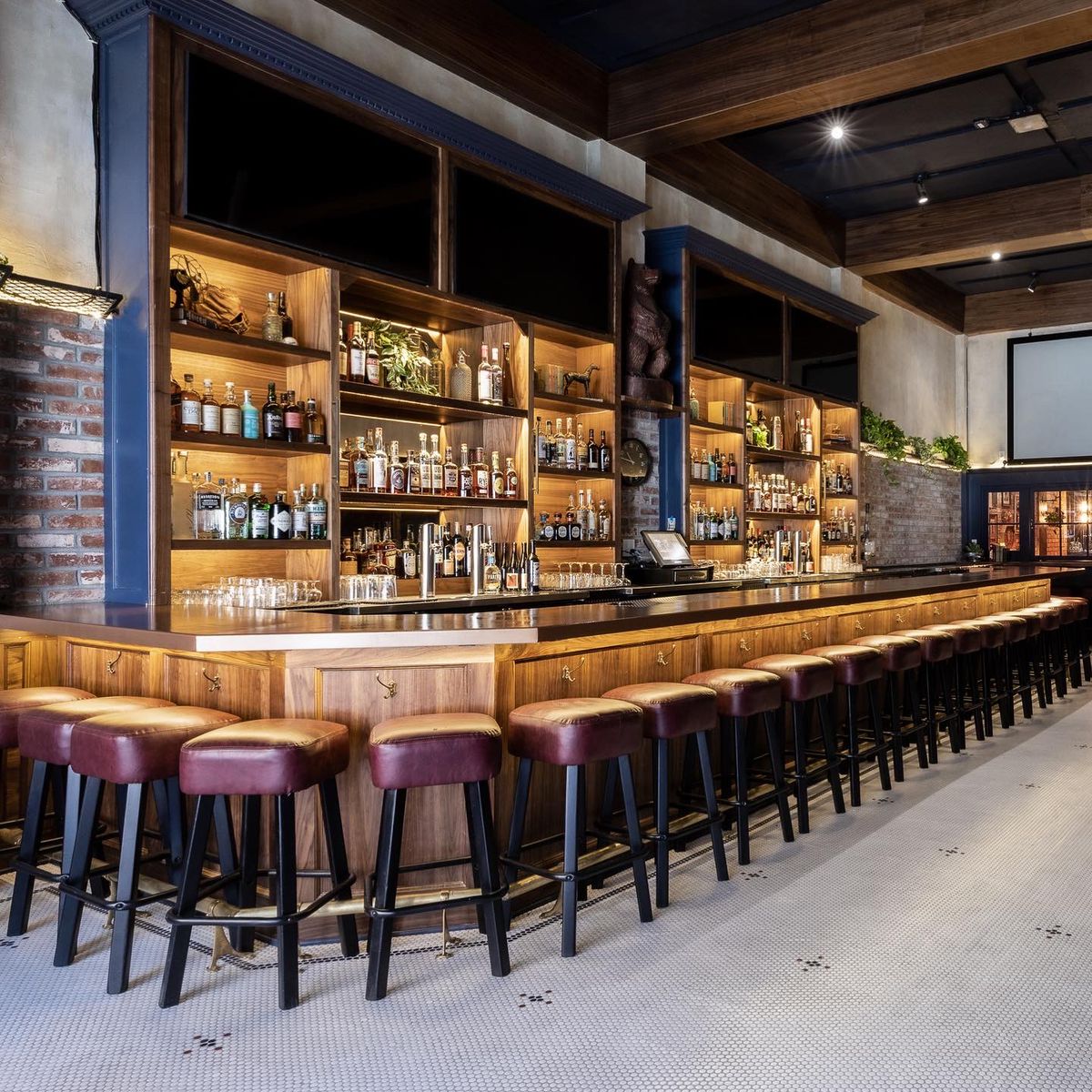 A view of a bar with leather stools.