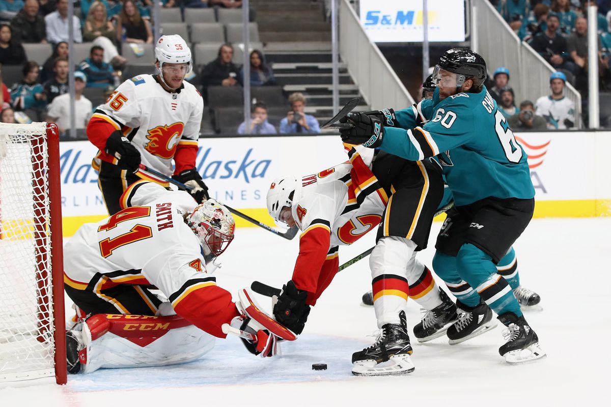 SAN JOSE, CA - SEPTEMBER 27: Mike Smith #41 and Travis Hamonic #24 of the Calgary Flames stop Rourke Chartier #60 of the San Jose Sharks from scoring during their preseason game at SAP Center on September 27, 2018 in San Jose, California.