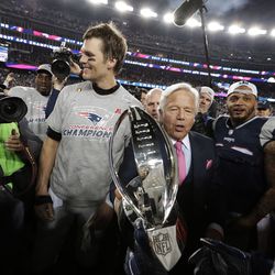 New England Patriots owner Robert Kraft, center, carries the trophy between quarterback Tom Brady, left, and safety Patrick Chung as they leave the field after the AFC championship NFL football game against the Jacksonville Jaguars, Sunday, Jan. 21, 2018, in Foxborough, Mass. The Patriots won 24-20. (AP Photo/David J. Phillip)