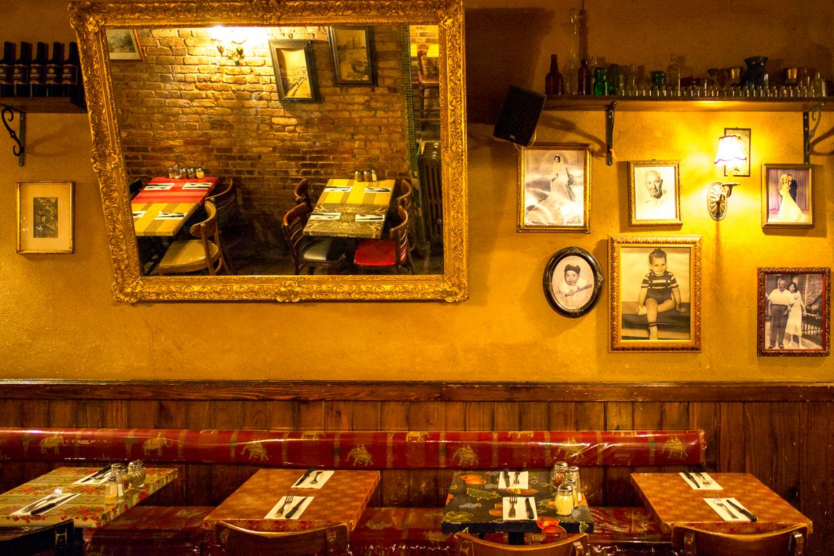 The wall of an East Village Italian restaurant, Lil’ Frankies, is decorated with mirrors and childhood photos.