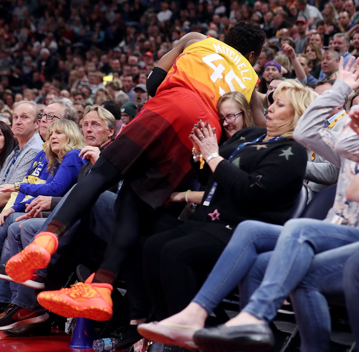 Utah Jazz guard Donovan Mitchell (45) crashes into the front two rows as the Utah Jazz and the Golden State Warriors play an NBA basketball game at Vivint Smart Home Arena in Salt Lake City on Wednesday, Dec. 19, 2018. Jazz won 108-103.