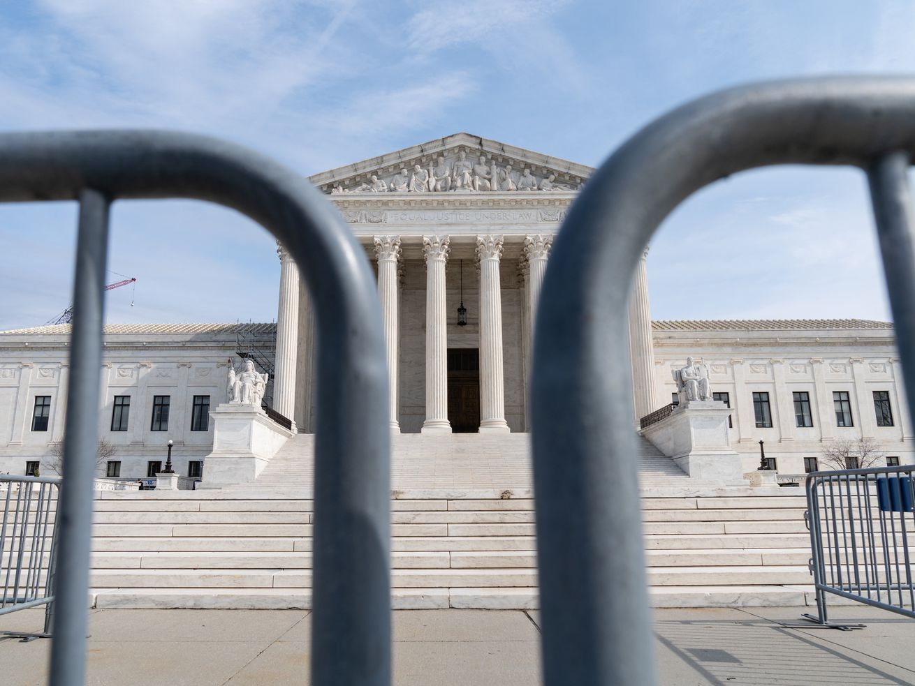 The US Supreme Court building exterior, seen from behind barricades.