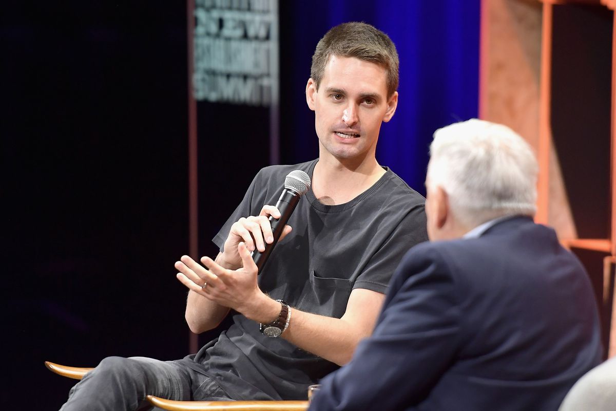Snap CEO Evan Spiegel onstage holding a microphone