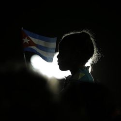 A girl holds a Cuban flag during a rally honoring late Fidel Castro at Antonio Maceo plaza, the day his ashes arrived to Santiago, Cuba, Saturday, Dec. 3, 2016. After a four-day journey across the country through small towns and cities where his rebel army fought its way to power nearly 60 years ago, Castro's remains arrived to Santiago for burial. 