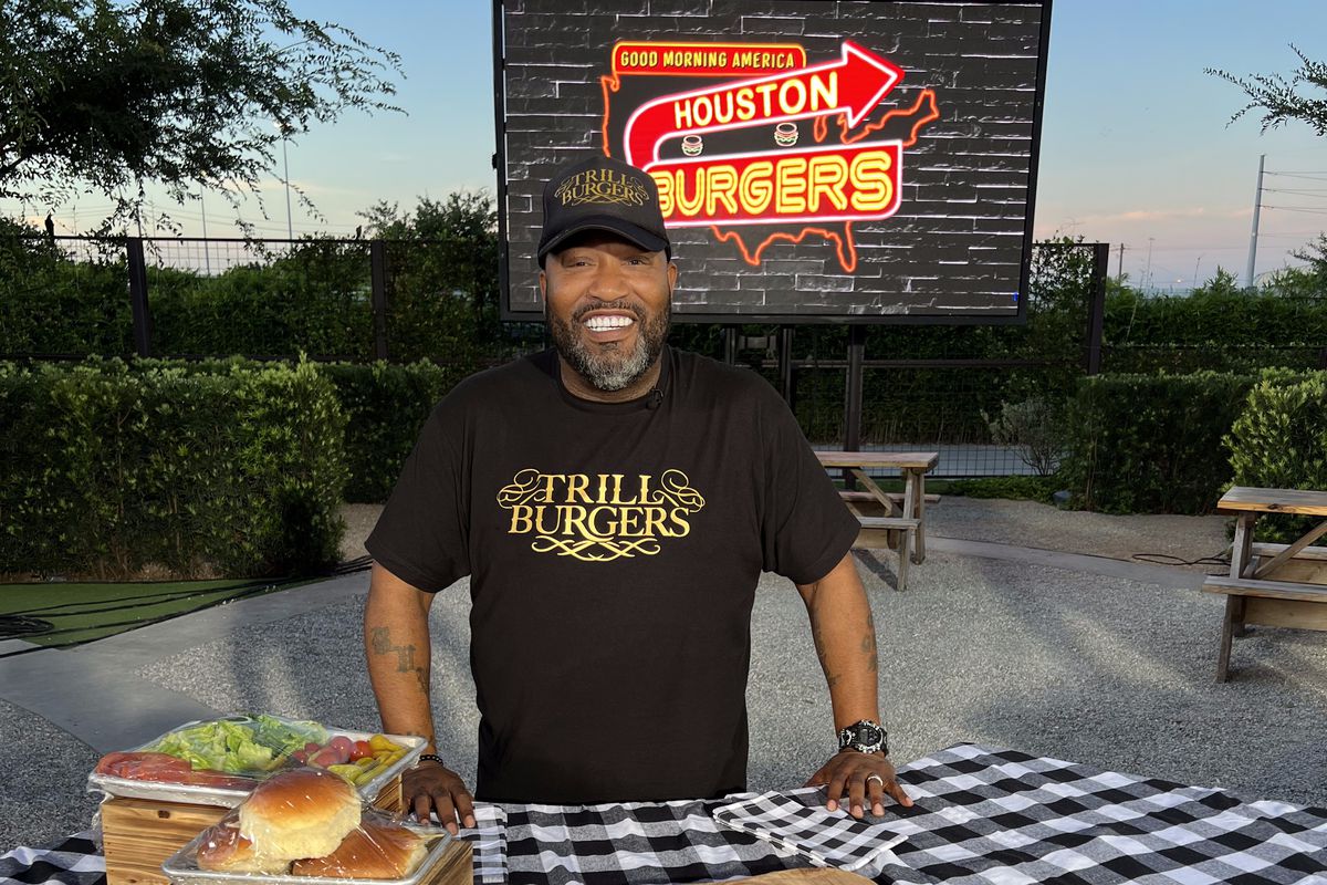 Houston hip hop artist Bun B standing with burger ingredients at a local competition.