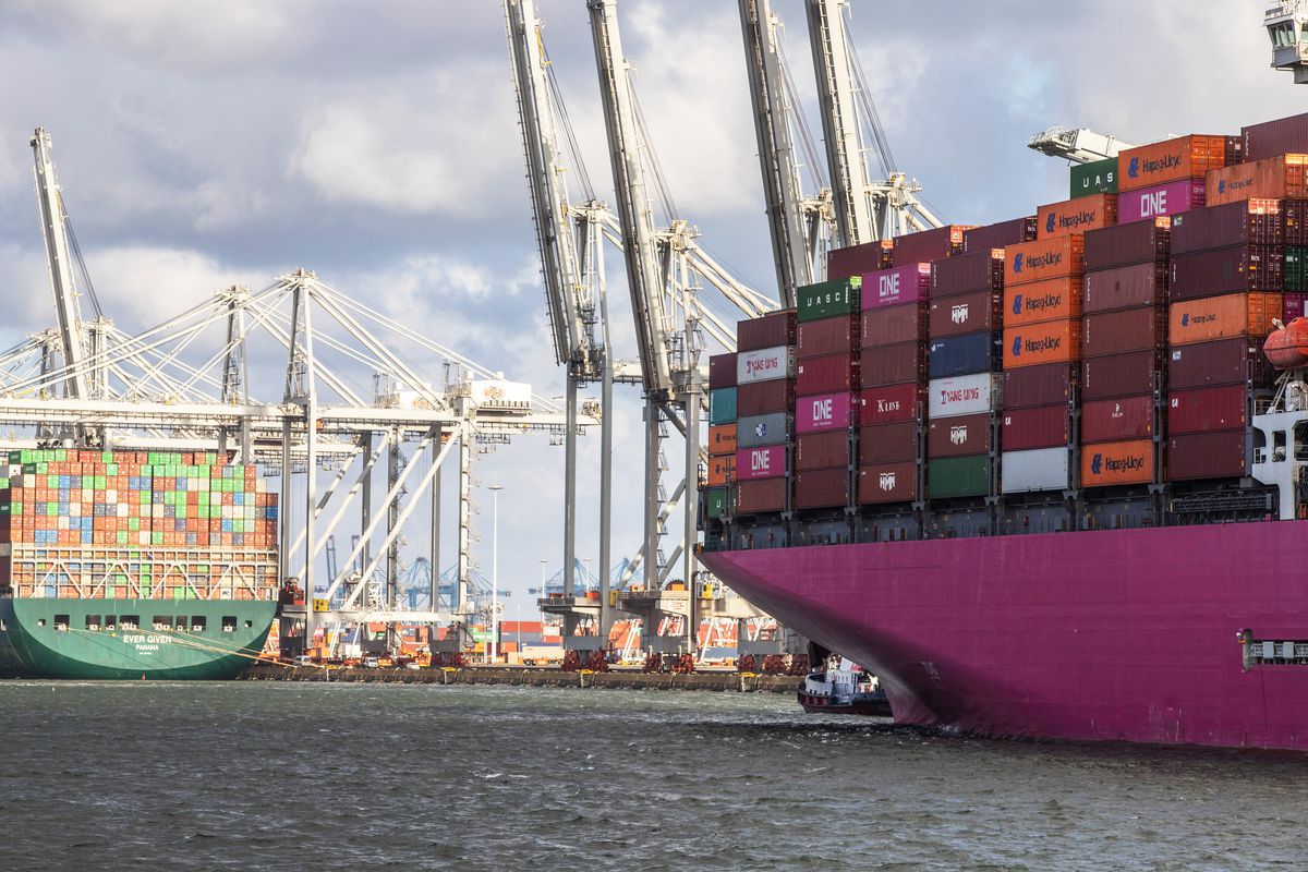 A container ship docked near the One Ibis cargo vessel at a port in Rotterdam, Netherlands.