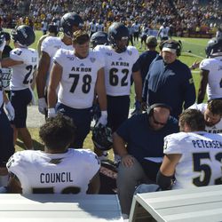 The Akron offensive line gets together for a quick rundown after a failed offensive possession. 