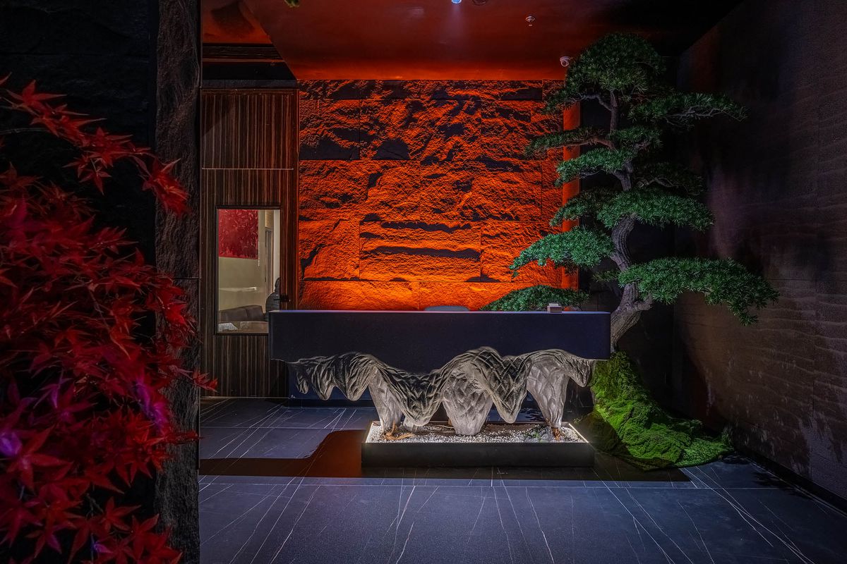Striking stone entrance to Array 36 with indoor foliage and red-lit wall.
