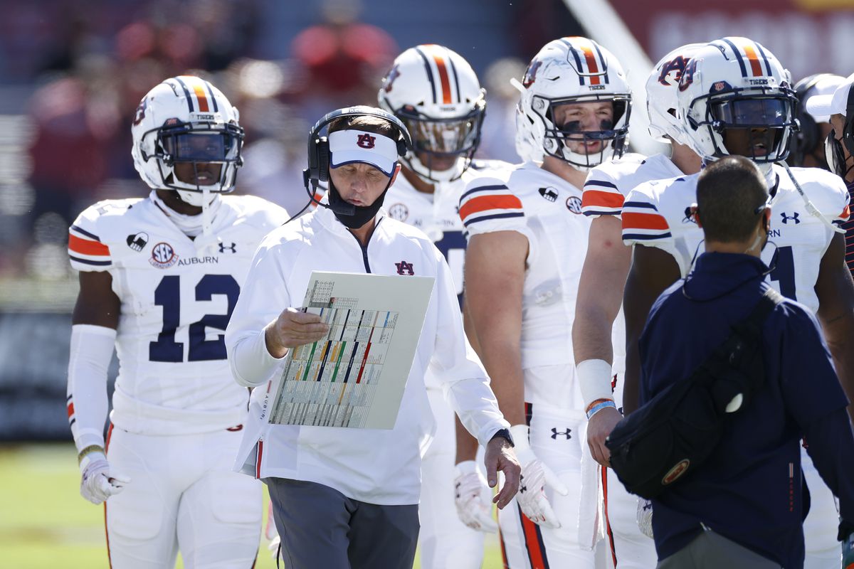Offensive coordinator Chad Morris of the Auburn Tigers looks over his play chart with a group of players on the sideline against the South Carolina Gamecocks during a game at Williams-Brice Stadium on October 17, 2020 in Columbia, South Carolina. The Gamecocks won 30-22.