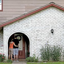 A family who identified themselves as friends of the victims, pause on the porch Thursday, July 10, 2014, after placing flowers and a framed photograph at the door of the home where a gunman killed six people Wednesday in Spring, Texas. The Harris County Sheriff?s Office says Ronald Lee Haskell was booked Thursday on a capital murder/multiple murders charge and held without bond. Authorities believe Haskell fatally shot two adults and four children on Wednesday night and critically wounded a 15-year-old girl, who called 911. (AP Photo/David J. Phillip)