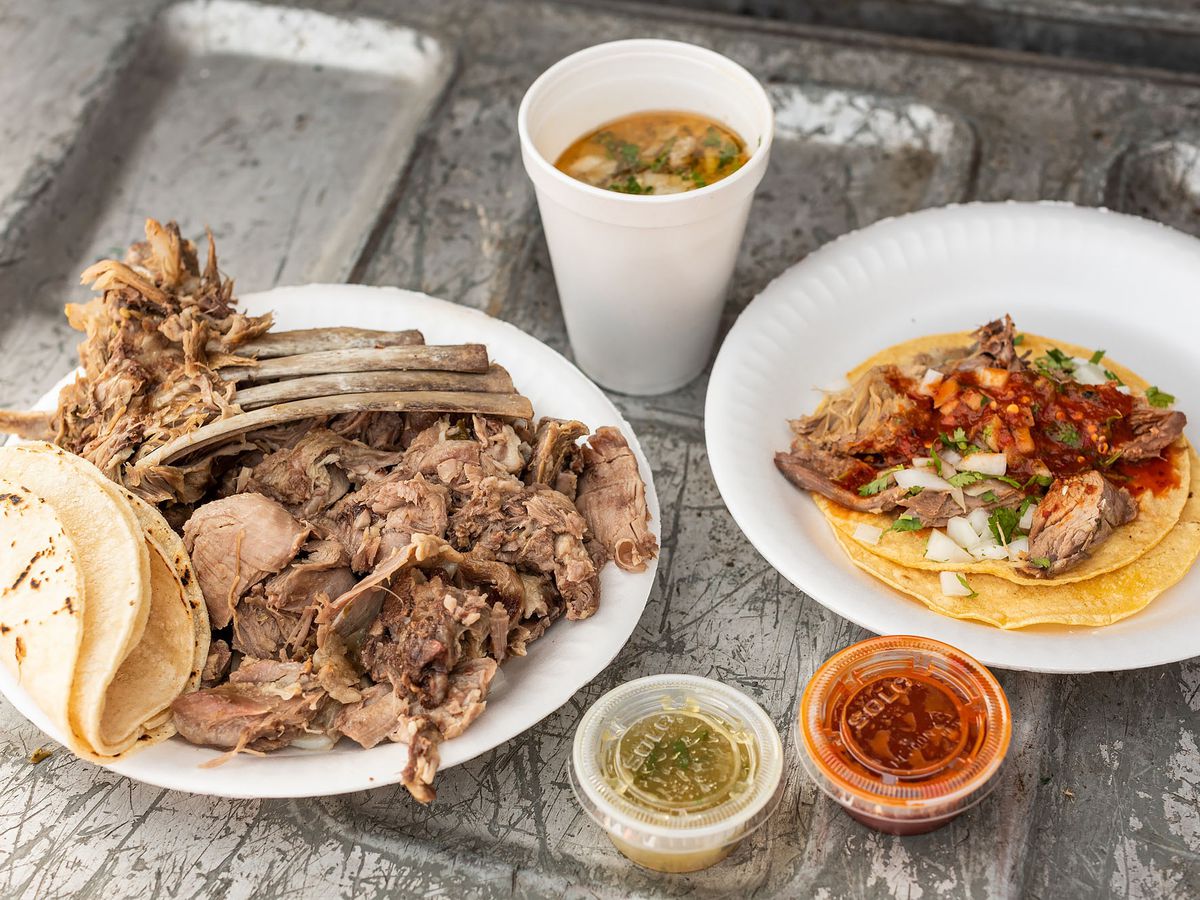 Barbacoa from Barbacoa Estilo Tlacotepec on a plate with a built taco and salsas with consomme.