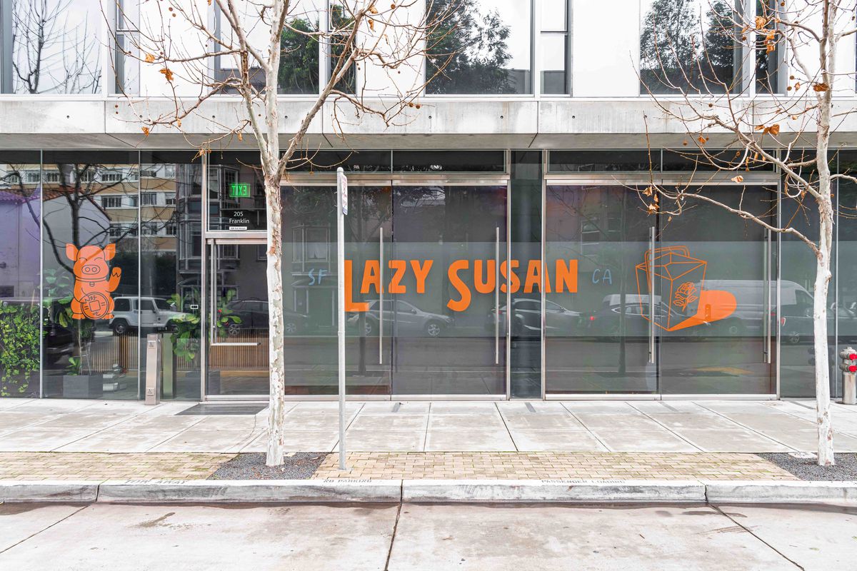 Exterior of Lazy Susan restaurant, with orange lettering a a waving pig logo