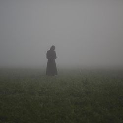 A migrant woman waits in a field at the northern Greek border station of Idomeni, Tuesday, March 8, 2016. Greek police officials say Macedonian authorities have imposed further restrictions on refugees trying to cross the border, saying only those from cities they consider to be at war can enter. 