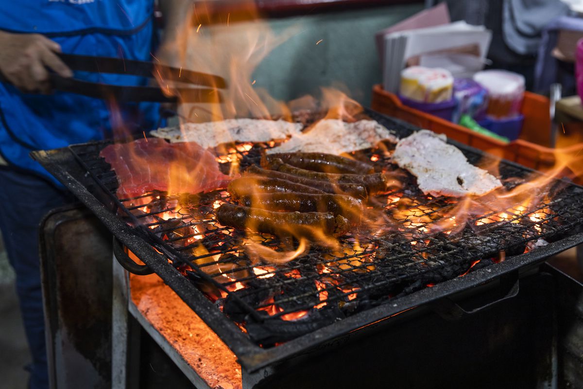 Meat surrounded by flames on a grill