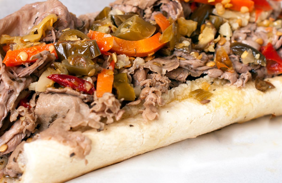 An Italian beef sandwich with hot peppers.
