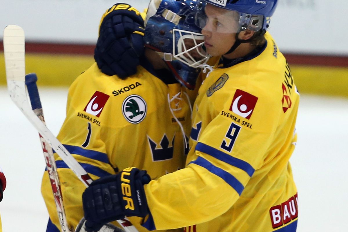Jacob De La Rose hugs his goaltender following Sweden's only loss of the tournament.