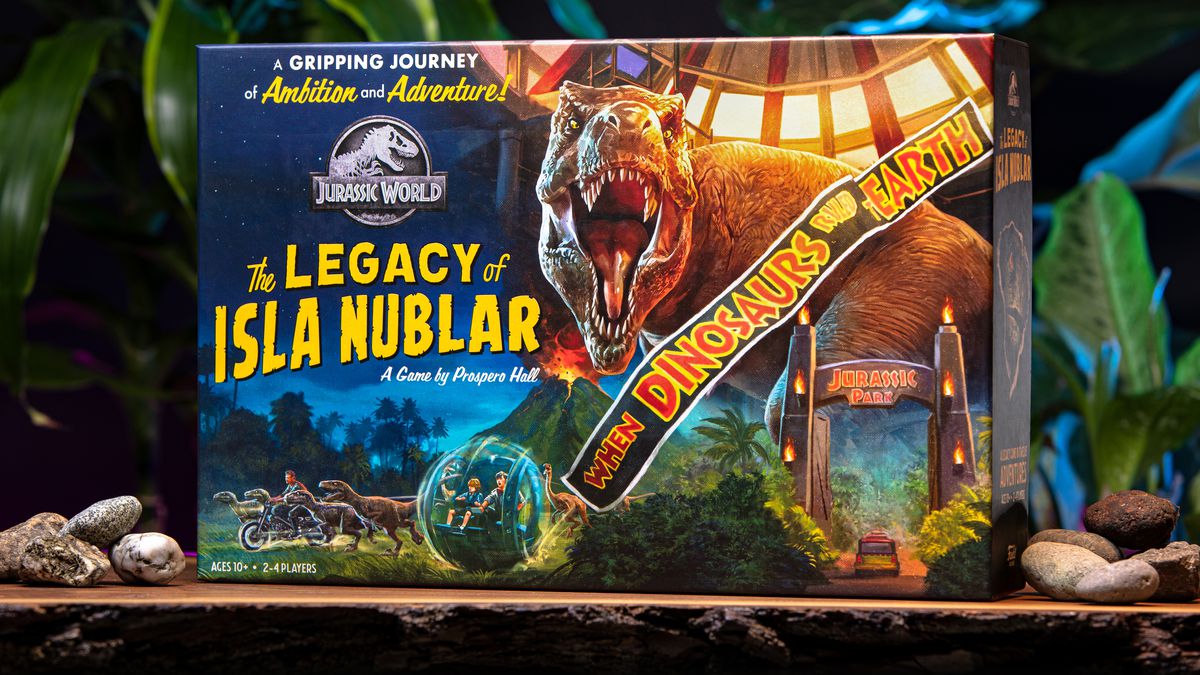 The cover for Jurassic World: The Legacy of Isla Nublar shows a T-rex looming over the gates of Jurassic Park.