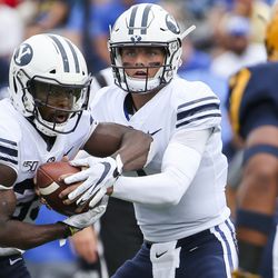 Brigham Young Cougars quarterback Zach Wilson (1) fakes a handoff to Brigham Young Cougars running back Emmanuel Esukpa (33) during the first half of an NCAA football game at The Glass Bowl in Toledo, Ohio on Saturday, Sept. 28, 2019.